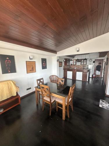 a living room with a table and chairs and a bed at Neem Tree Ambalangoda in Ambalangoda