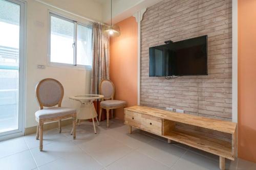 a living room with a flat screen tv on a brick wall at 花蓮雲朵朵民宿 電梯附停車場 in Jian