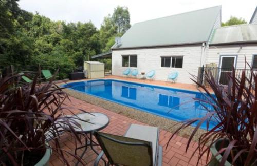 a swimming pool in front of a house at Quiet Country Retreat in Forster