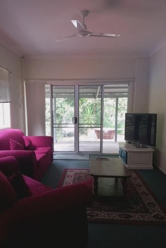 a living room with a pink couch and a table at Quiet Country Retreat in Forster