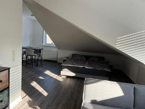Zimmer im Dachgeschoss mit einem Bett und einem Tisch in der Unterkunft Appartement 6 in Hilter in Hilter am Teutoburger Wald