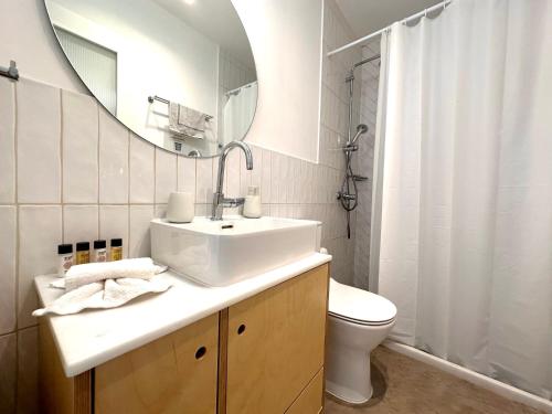 Un baño con lavabo, inodoro y espejo. en Port view apartment Aegina, en Aegina Town