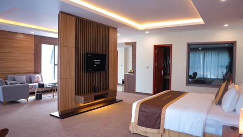 a hotel room with a bed and a television in it at YEN BIEN LUXURY HOTEL in Ha Giang