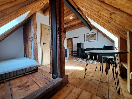 Loft con cama y mesa en una habitación en Górskie apartmenty Kowary, en Kowary