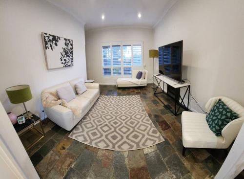 - un salon avec un canapé et un piano dans l'établissement Beautiful and cozy home, à Glenunga