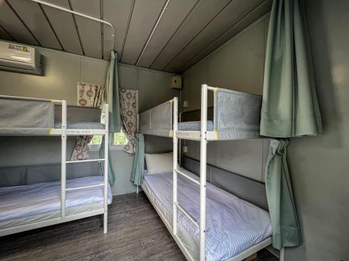 a room with three bunk beds in a room at 鉄木彩虹小屋 in Yü-lan