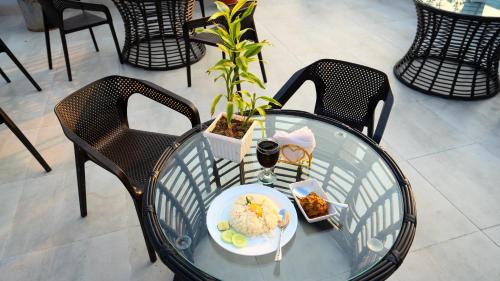 une table en verre avec une plaque de nourriture dans l'établissement Xpressmall Hotel near Dhaka Airport, à Dhaka