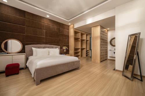 a bedroom with a large bed and a mirror at Tashi Apartment in Da Nang