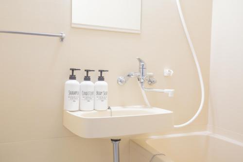 a bathroom sink with three bottles on it at walk to JR Shibuya sta.-EoE3 in Tokyo