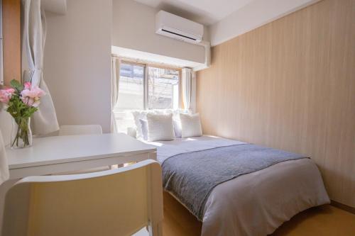 ein kleines Schlafzimmer mit einem Bett und einem Fenster in der Unterkunft walk to JR Shibuya sta.-EoE3 in Tokio