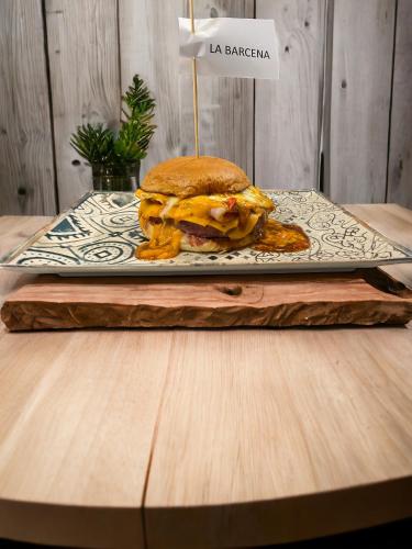 a sandwich on a plate on a wooden table at Hostal Restaurante La pinta in Ampuero