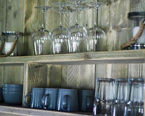 a shelf with wine glasses and cups on it at Sandringham Safari Tent Lodge in South Creake