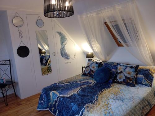 a bedroom with a bed with a blue comforter at La Gerbaudiere Chambres&Table d hotes proche Mont Saint Michel CUISINE MAISON in Notre-Dame-du-Touchet