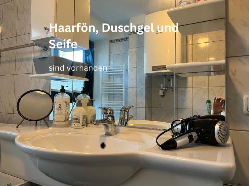 a bathroom sink with a hairbrush and a mirror at Wohnen beim Stadtpark in Graz