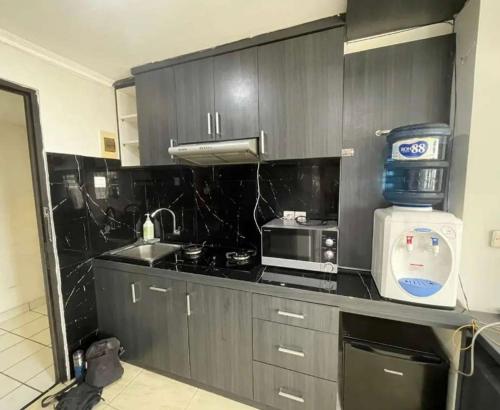 萬隆的住宿－Loesama 08，厨房配有黑色橱柜、微波炉和台面