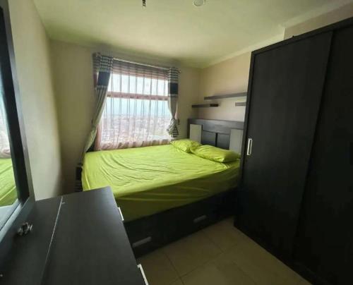 ein kleines Schlafzimmer mit einem Bett und einem Fenster in der Unterkunft Loesama 08 in Bandung