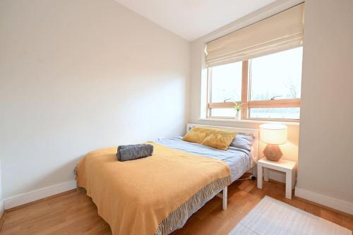 łóżko w pokoju z oknem w obiekcie London Apartment Next To Station + Parking w mieście Beckenham
