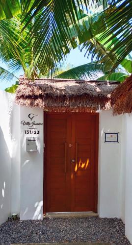a red door to a white building with a palm tree at CYAN Jasmine Pool Villa - Fisherman's Village in Bophut