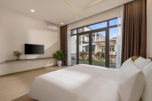 a bedroom with a white bed and a large window at Tashi Apartment in Da Nang