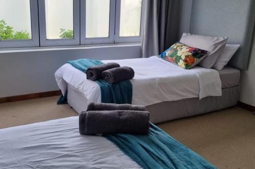 Dos camas en una habitación con toallas. en Marlyn on Oyster Bay, en Oyster Bay