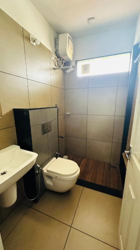 a bathroom with a toilet and a sink at Western Ghats Holiday Home in Kalpetta