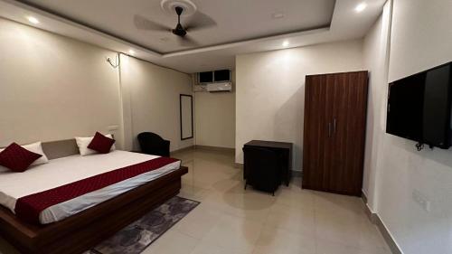 a bedroom with a bed and a flat screen tv at Long Acres in Guwahati