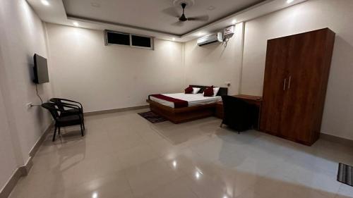 a bedroom with a bed and a chair in a room at Long Acres in Guwahati
