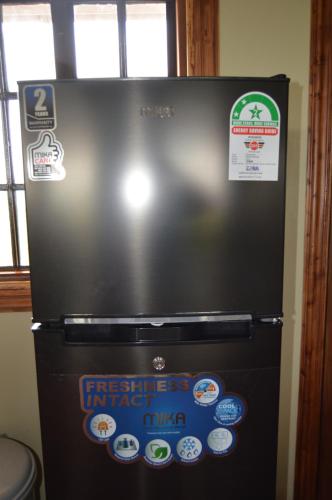 einen schwarzen Kühlschrank mit Aufklebern darüber in der Unterkunft Wild Amboseli Ndovu Cottage. in Amboseli-Nationalpark