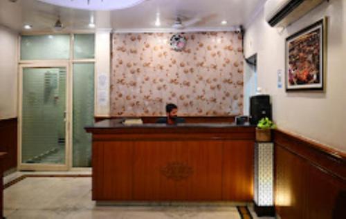 a man is sitting at a counter in a restaurant at Hotel Suncity Prayagraj in Prayagraj
