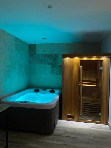 Cote spa suite nord في Saint-Victoret: حوض استحمام مع ضوء أزرق في الحمام