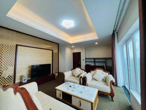 Duy Tân Quảng Bình Hotel & Resort في دونغ هوي: غرفة معيشة مع كنبتين وتلفزيون