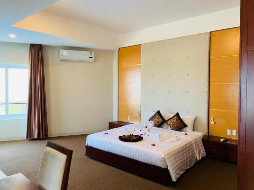 Duy Tân Quảng Bình Hotel & Resort في دونغ هوي: غرفة في الفندق مع سرير مع وعاء عليه