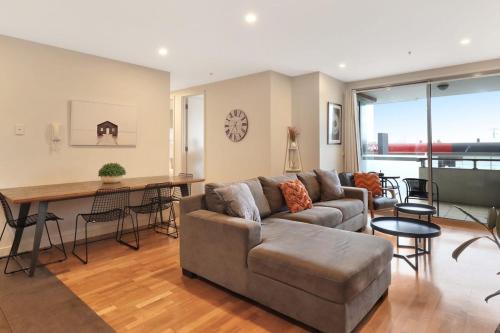 a living room with a couch and a table at Terminus Apartment I Steps from Geelongs Buzz in Geelong