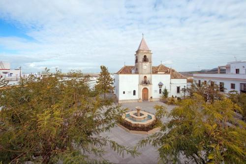 a church with a steeple and a fountain in front of it at Casa Mar y Montaña in Paterna de Rivera