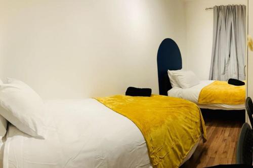 a bedroom with two beds with yellow sheets at *Super central 20min to Big Ben* in London