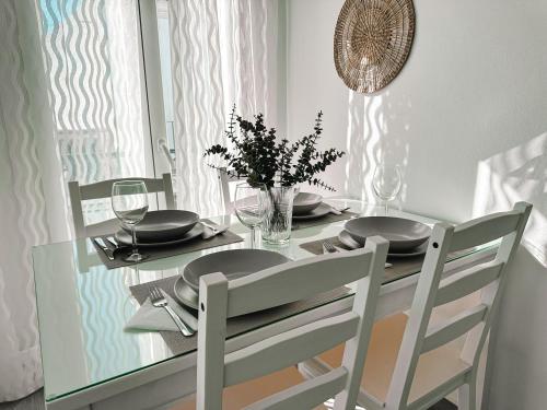 mesa de comedor con 2 sillas y mesa con platos y vasos en Casa Mar y Montaña, en Paterna de Rivera