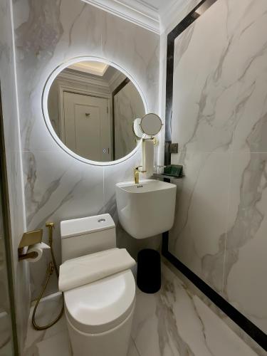 a bathroom with a white toilet and a mirror at Grand Eska Hotel & Suites Batam in Nagoya