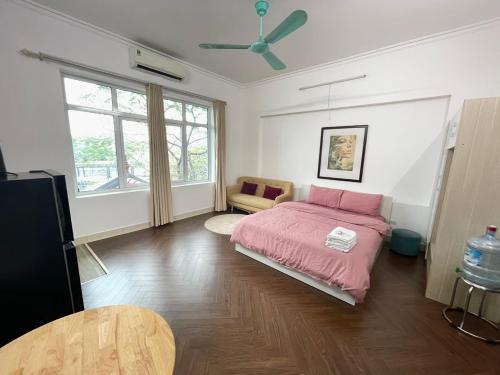 een slaapkamer met een roze bed en een plafondventilator bij Chill studio close Ho Tay ! (13-3.1) in Hanoi