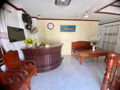 uma sala de estar com uma banheira, uma mesa e cadeiras em Xuan Keo place house 2 em Luang Prabang