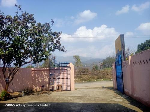 a gate in a fence with a mountain in the background at Prince Guest House in Panchkula