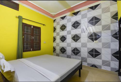 a bedroom with a bed and a tiled wall at Prince Guest House in Panchkula