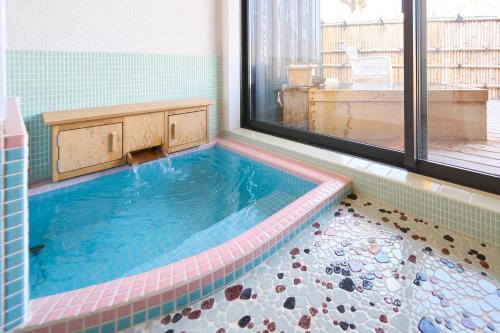 a swimming pool in a bathroom with a window at Suite Villa Atami Bettei Soubaian in Atami