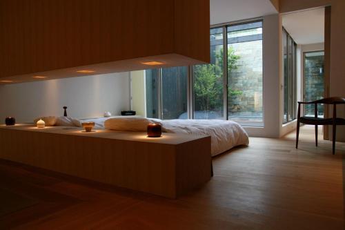 a bedroom with a large bed and a large window at Tara Dakeonsen Kanigoten in Tara
