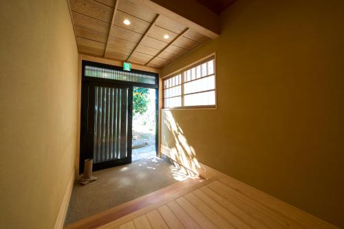 an empty room with a door and a window at Suite Villa Atami Bettei Soubaian in Atami