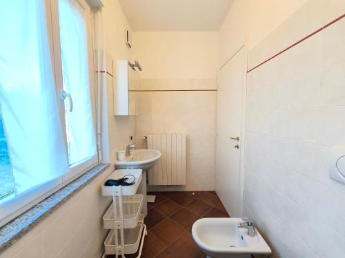 La salle de bains est pourvue d'un lavabo, de toilettes et d'une fenêtre. dans l'établissement Villa la Tranquilla, à Baveno