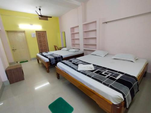 a room with two beds in a room at Shivangi Eco in Puri