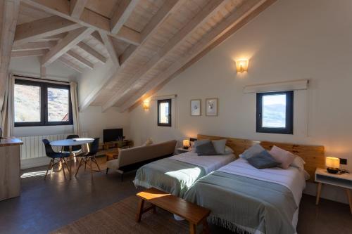 Villafufre的住宿－Sandoñana Old Palace Lodge，一间带两张床的卧室和一间客厅