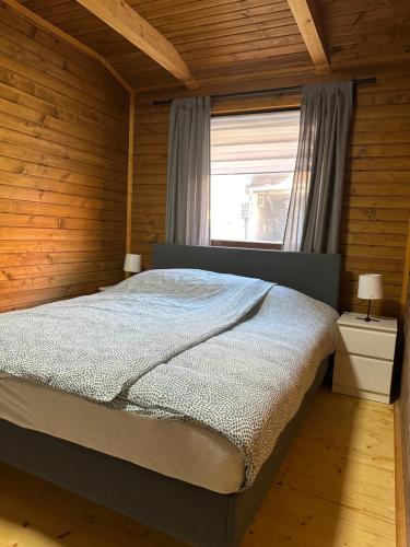 ein Schlafzimmer mit einem großen Bett in einem Holzzimmer in der Unterkunft Wood House Nyíregyháza in Nyíregyháza