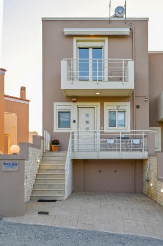 a house with a staircase and a balcony at Sand Lily in Plakias