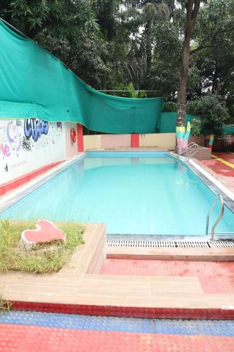 een groot zwembad met een glijbaan bij Vellankani Resort Gorai in Mumbai